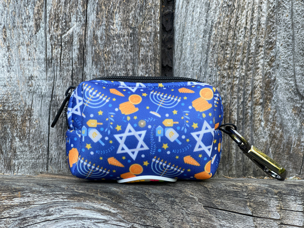 A festive Hanukkah dog waste bag holder featuring a blue design with menorahs, dreidels, and Stars of David.