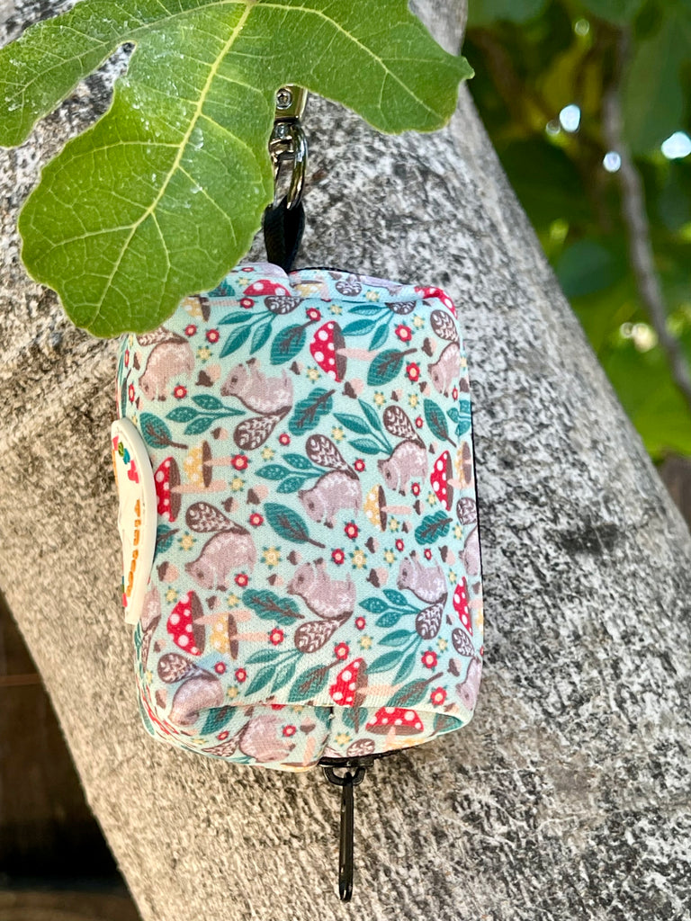 Stylish mint green dog waste bag dispenser with adorable gray squirrel design, perfect for on-the-go puppy parents.