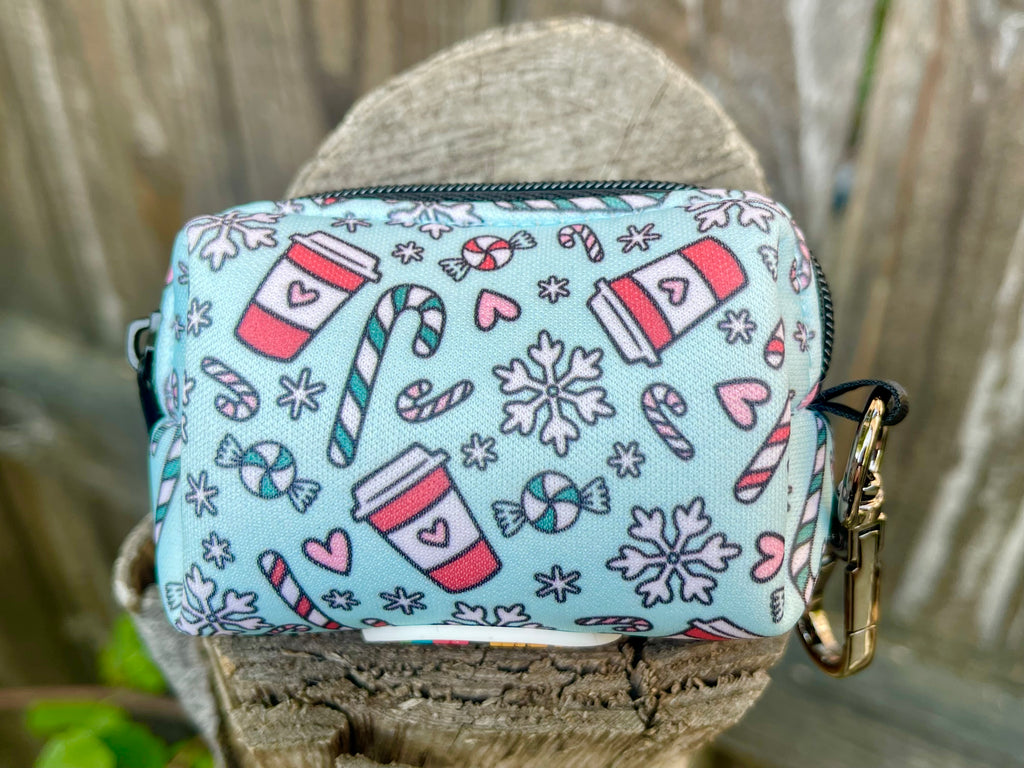 Back of the Peppermint Mocha poop bag holder with winter-themed pattern of coffee cups, snowflakes, and sweets, placed on rustic wood.