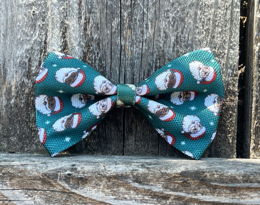 let your dog join in on the holiday festivities with our hunter green with Christmas Santa heads on canvas dog bowtie. Has an elastic attachment that easily attaches to any leash.