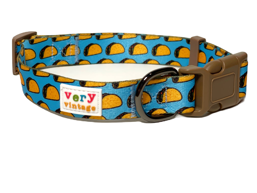 light blue with yellow taco dog collar with brown plastic buckle and slider. It is budget friendly and soft and secure for dog walks and everyday use.