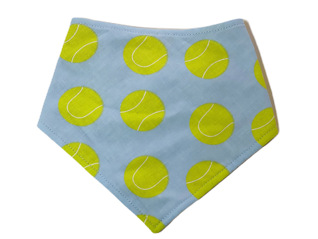 Handmade dog bandana featuring a light blue-gray background with vibrant lime green tennis ball print. Adjustable with three snaps and made from soft, breathable fabric for a comfortable fit.