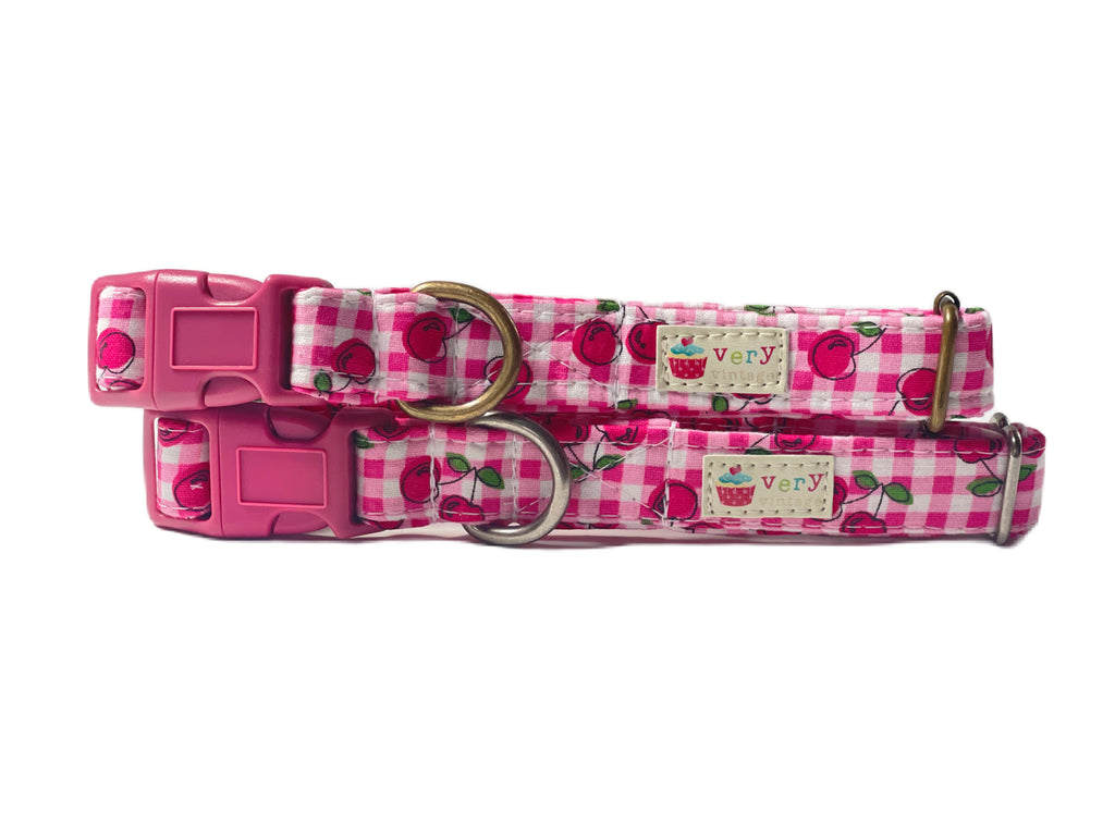 Handmade organic cotton pet collar featuring a dark bright pink and white gingham plaid pattern with cute red cherries. Perfect for summer, available in custom sizes for dogs and cats, with antique brass or silver hardware and a breakaway buckle for added safety for cats.