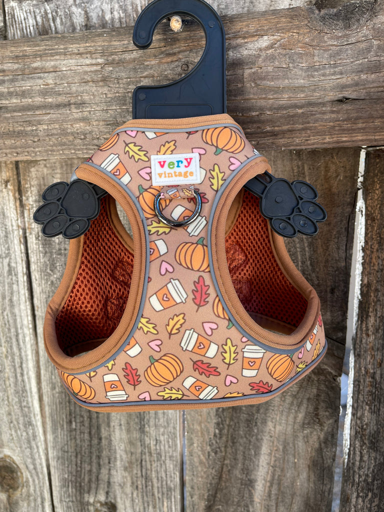 A stylish and functional dog harness vest with a pumpkin spice latte design. The adjustable straps and secure closure provide a comfortable and safe fit for your small dog.