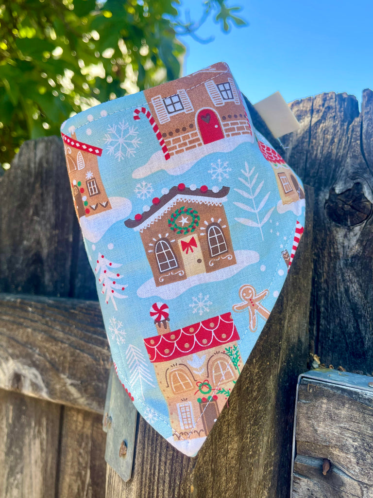 Festive gingerbread house dog bandana on blue background, eco-friendly snap-on Christmas scarf”