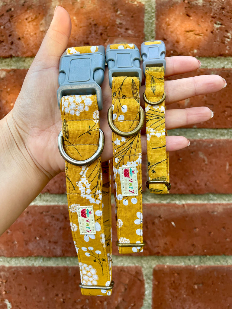 Eco-friendly floral dog collar in mustard yellow with delicate botanical print, shown against a rustic brick wall. Handmade in Los Angeles using organic cotton and durable antique silver or antique brass hardware for a stylish, sustainable pet accessory.