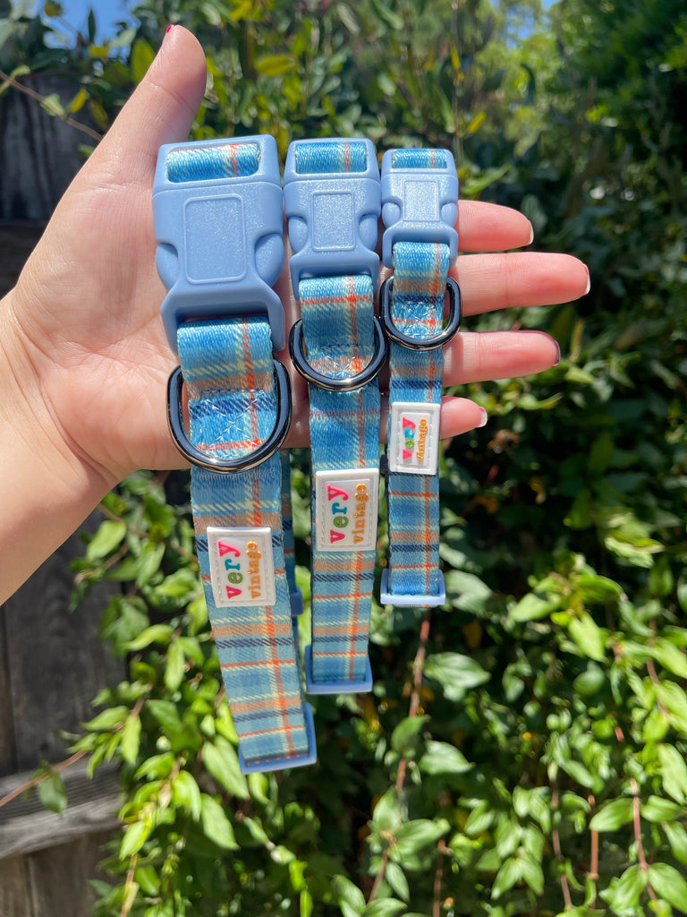 Close-up of a dog collar showing the plaid pattern and hardware.