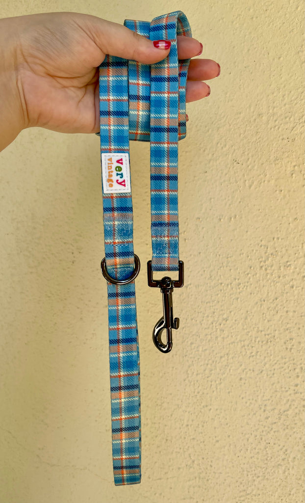 Light blue, orange, navy, and white plaid dog leash made from recycled materials for safe and stylish walks.