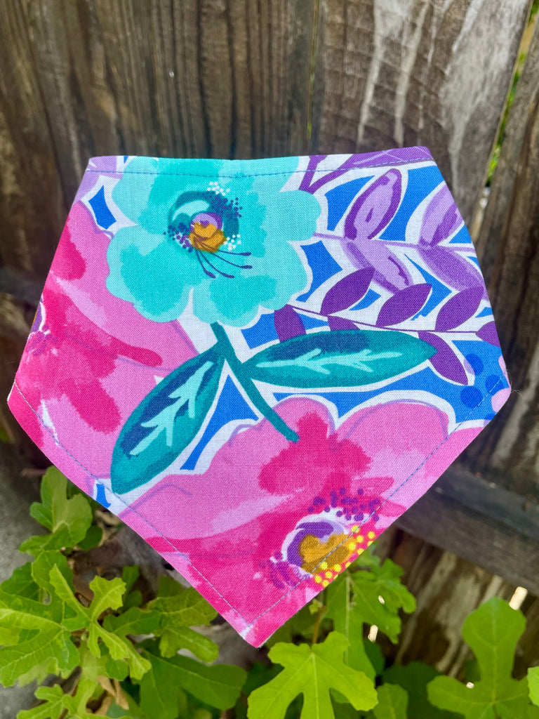 Periwinkle Floral snap-on dog bandana laid flat to show large flower print in aqua, fuchsia, and purple on pink background