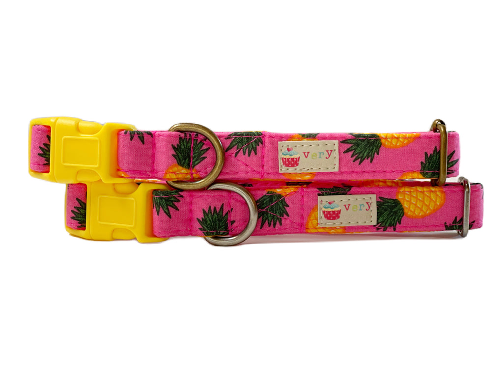 A close-up of the hot pink collar showcasing the vibrant yellow pineapple pattern. Handmade from organic cotton and finished with antique brass or antique silver hardware, this collar is full of tropical summer vibes.