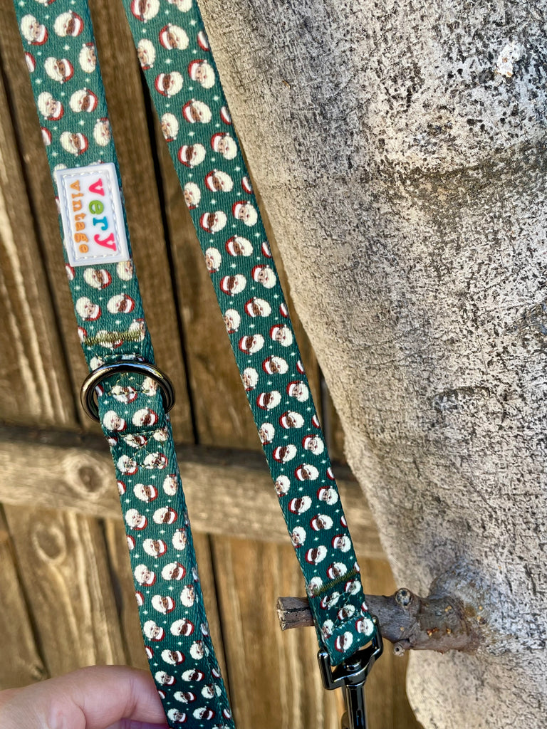 Green Santa print dog leash with black metal clip and D-ring detail