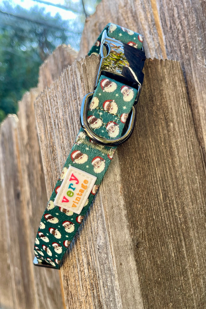 Close-up of green Retro Santa dog collar with metal buckle and Santa print
