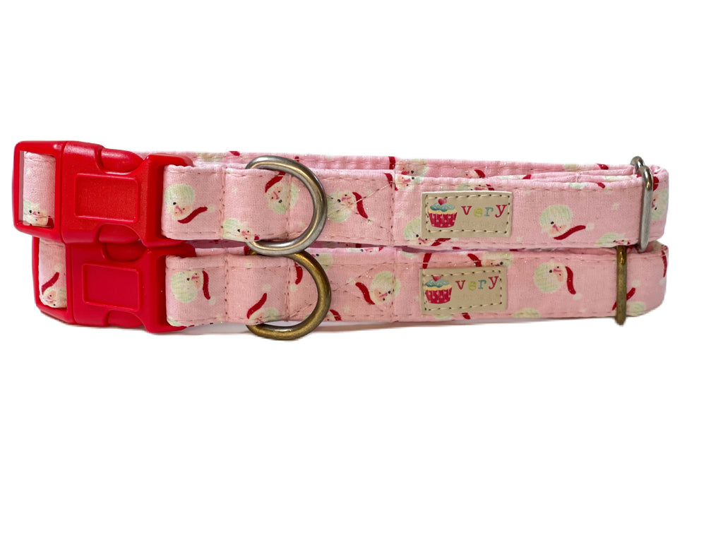 A close-up of the light pink Christmas collar featuring tiny Santa heads for a festive, playful design. Handmade from organic cotton with antique brass or antique silver hardware, this collar adds a cheerful touch to your pet’s holiday look.