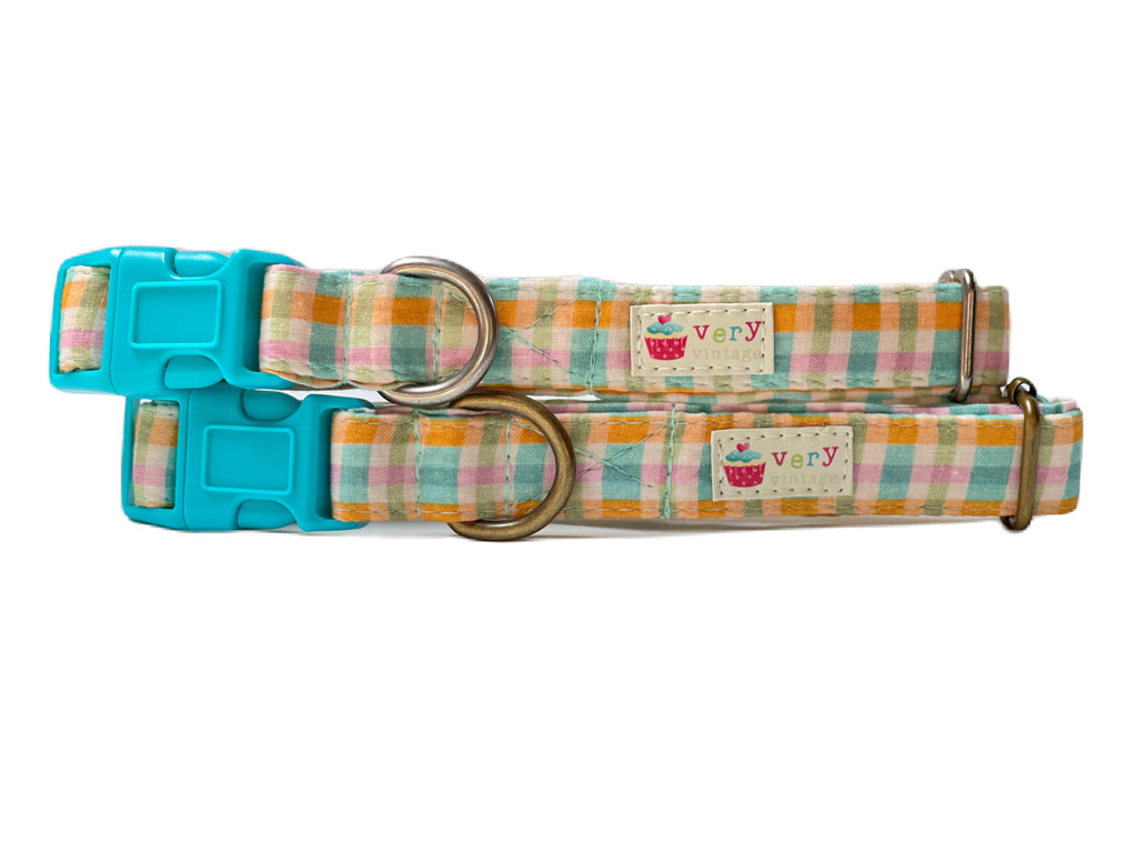 A close-up of the golden yellow and teal blue plaid  with a touch of light pink collar, capturing the vibrant, summery design. Made from organic cotton and finished with antique brass or antique silver hardware, this collar is perfect for sunny days.