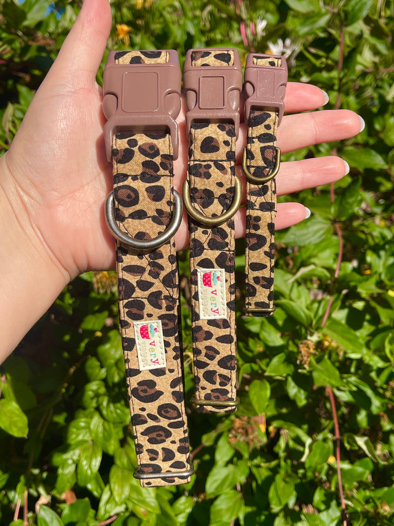 Stylish handmade leopard print collar for pets, shown outdoors with a greenery background. Features organic cotton and eco-friendly construction.