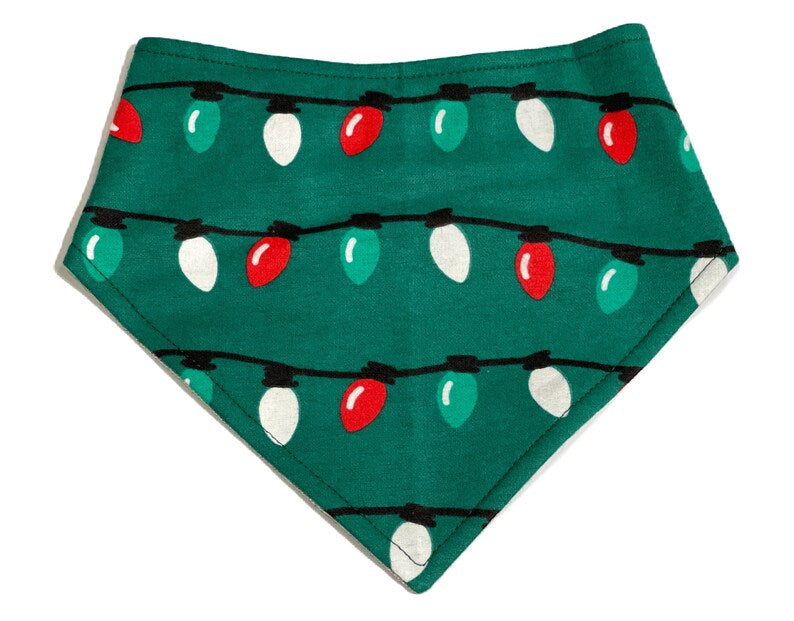 Hunter green dog bandana with a festive pattern of colorful Christmas lights. Made from organic cotton, this adjustable bandana features three snaps for a secure fit. Available in various sizes and handmade in the USA.