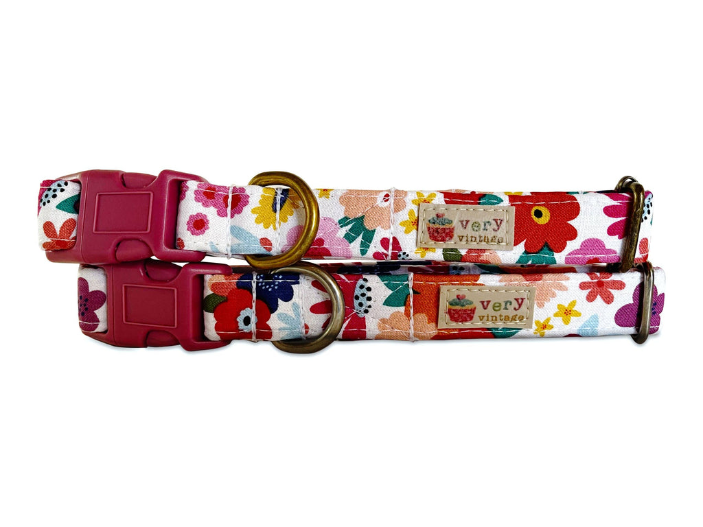 Handmade dog and cat collar featuring a white background with vibrant pink, yellow, and colorful flowers. Perfect for spring, this collar offers a soft and stylish look, crafted from organic cotton for a comfortable fit.