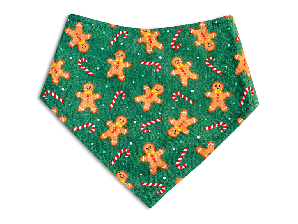 Handmade dog bandana with a bright green background featuring cute brown gingerbread men and red and white candy canes.