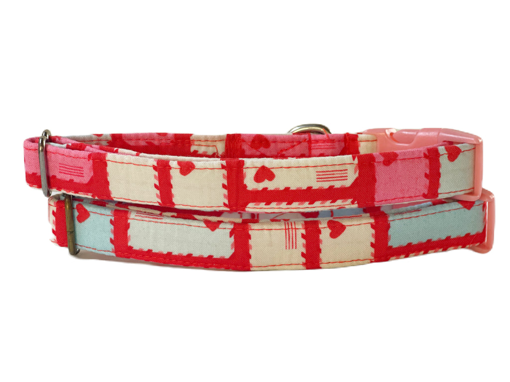 The "Love Letter" dog collar in different sizes, photographed outside to highlight its romantic design. The collar features envelopes with hearts on a red background, making it an ideal accessory for Valentine's Day or any romantic occasion.