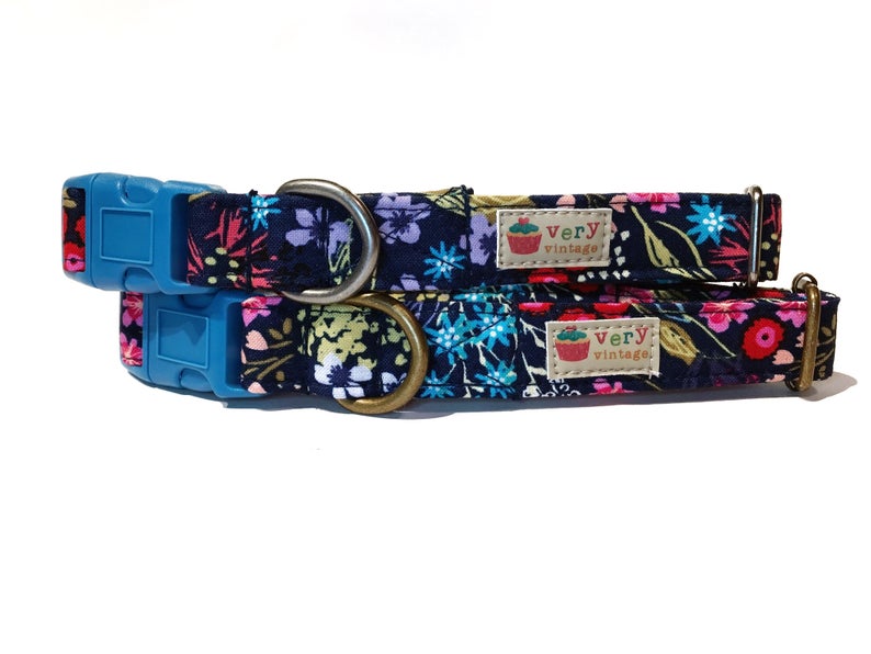 A close-up of the dark blue collar with a colorful wildflower-inspired floral pattern, showcasing the vibrant design. Available with antique brass or antique silver hardware, this collar adds a nature-filled touch to your pet’s look. Cat collars have safety buckles. Made in the USA.