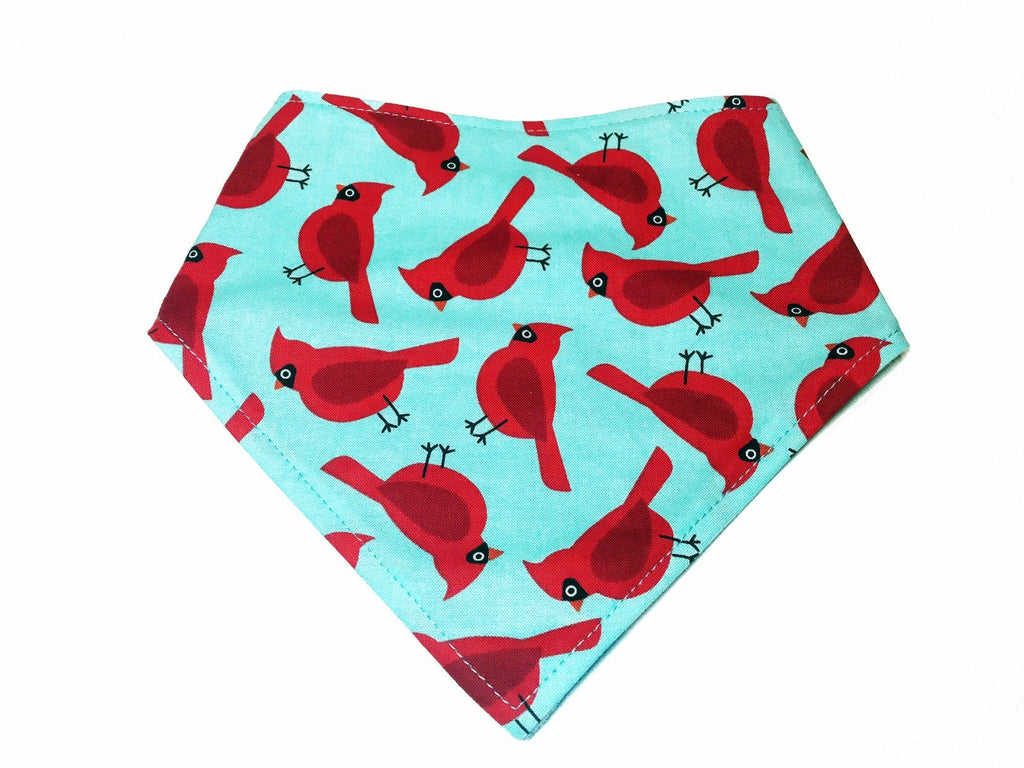 Light blue dog bandana with a red cardinal bird pattern. Made from organic cotton, this adjustable bandana features three snaps for a secure fit. Available in various sizes and handmade in Los Angeles.