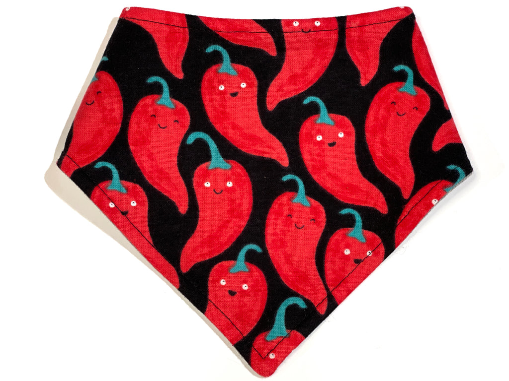 Black dog bandana with a playful pattern of red chili peppers with kawaii faces. Made from organic cotton, this adjustable bandana features three snaps for a secure fit. Available in various sizes and handmade in Los Angeles.