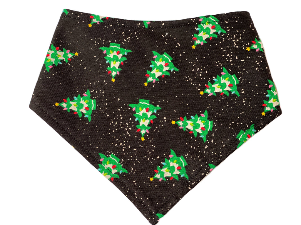 Black dog and cat bandana with a festive pattern of green Christmas trees and white snow. Made from organic cotton, this adjustable bandana features three snaps for a secure fit. Available in various sizes and handmade in the USA.