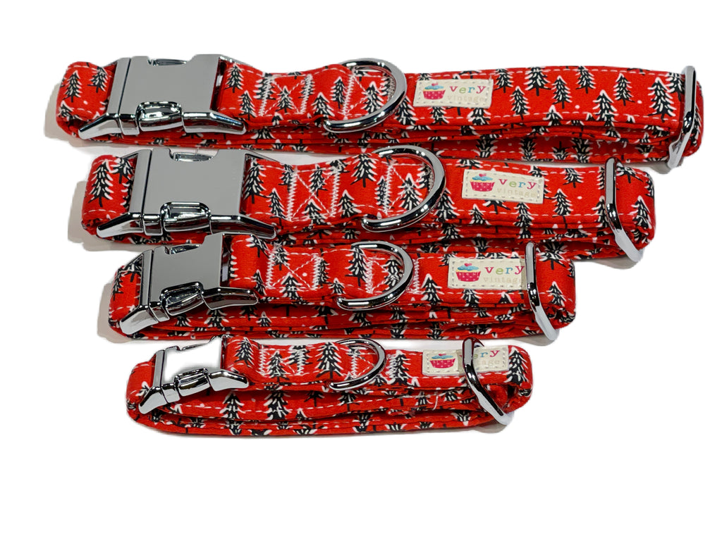 A variety of sizes of the pine tree collar, displayed outdoors to highlight the festive design and true colors in natural light. With silver hardware and a metal buckle, this collar adds a seasonal, holiday touch to your pet’s look.