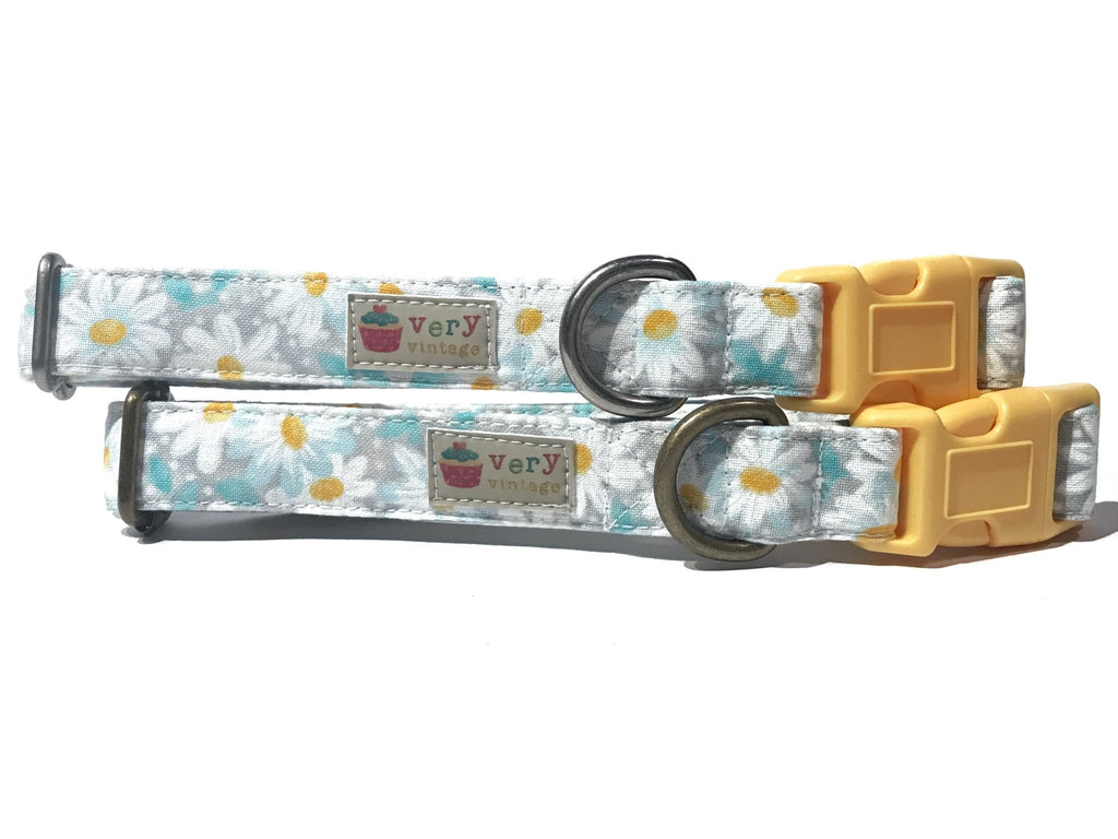 Handmade organic cotton dog and cat collar featuring a soft gray background with white daisies and yellow centers. A stylish and subtle floral design perfect for pets who love a fresh, classic look. Handmade in Los Angeles.