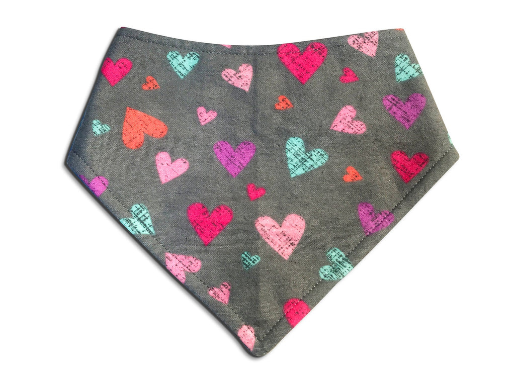 Handmade Valentine's Day bandana for dogs, featuring a gray background and colorful hearts, eco-friendly fabric, and adjustable snap closures for a comfortable fit.