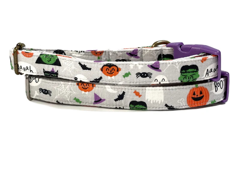 A flat lay of the gray dog collar with a variety of colorful monsters, each with unique features like big eyes, sharp teeth, and quirky expressions. The collar’s soft cotton fabric is complemented by a pink buckle, making it both a cute and durable choice for your furry friend.