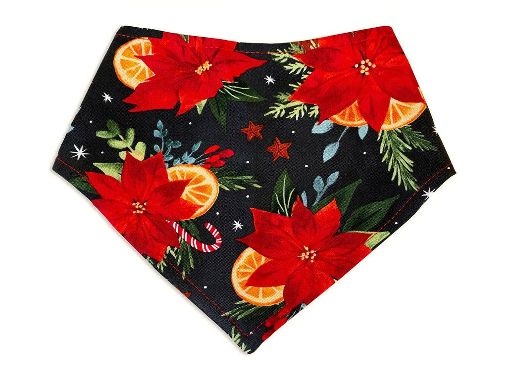 Handmade dog bandana in a black or dark gray with christmas poinsettias, candy canes and orange slices. 3 snaps on back for an adjustable and secure fit.