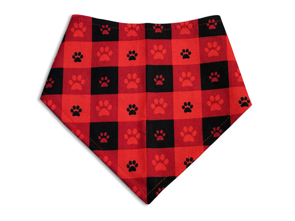 Eco-friendly snap-on dog bandana in red and black buffalo plaid with paw prints. Handmade in the USA with organic cotton for a comfortable and durable fit.