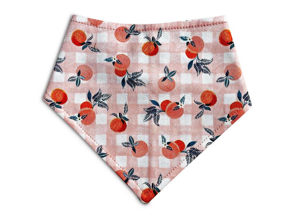 Handmade in Los Angeles. Snap-on bandana for dogs and cats featuring a peach and white gingham pattern with a playful peach design.