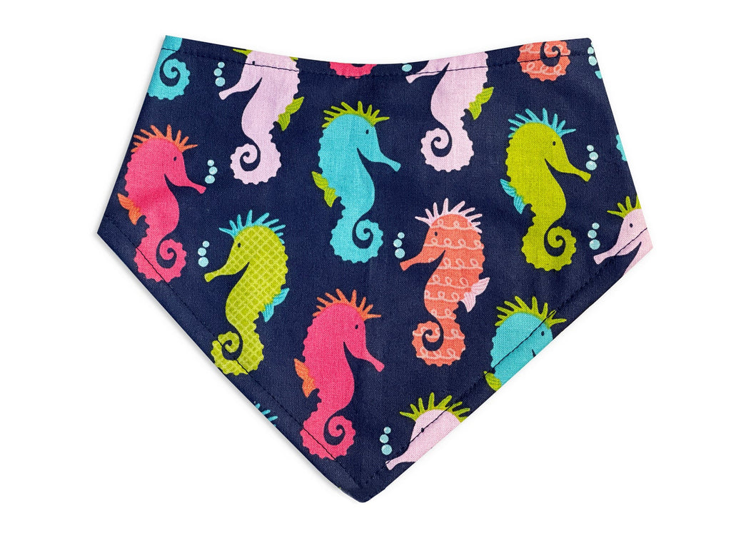 Navy blue pet bandana featuring colorful, multicolored seahorses in a nautical ocean-inspired design. Perfect for dogs and cats.