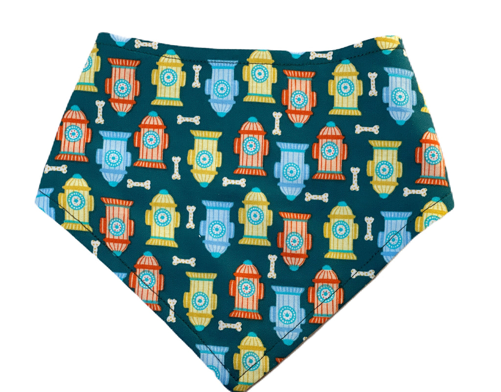 a teal blue green dog bandana with yellow, blue and orange fire hydrants and cream bones. Handmade in Los Angeles.