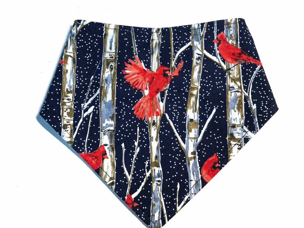 Handmade in Los Angeles. A dog bandana in dark blue with white birch trees and bright red cardinal birds. Perfect for Christmas and the holiday season! 3 snaps on the back for a secure and adjustable fit.